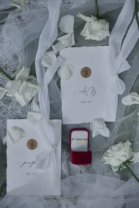 Nhẫn cưới và thiệp cưới trên nền voan trắng
